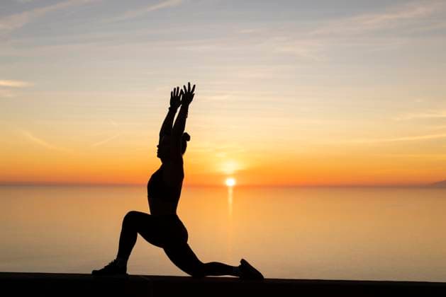 Woman with arms raised practicing yoga in front of sea model released, Symbolfoto, LJF02458