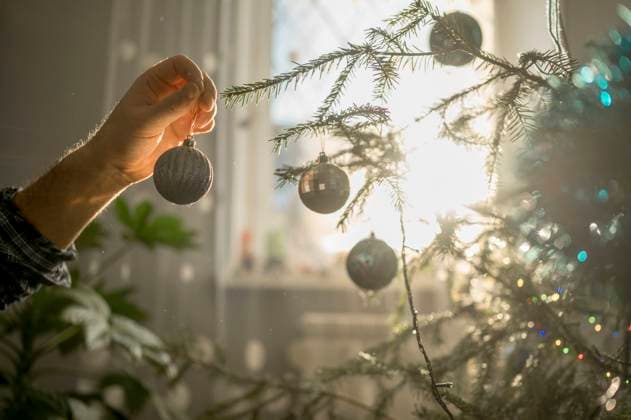 Hand of man decorating Christmas tree at home model released, Symbolfoto property released, ANAF00907