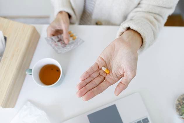 Hand of woman holding capsule pill model released, Symbolfoto property released, TYF00583