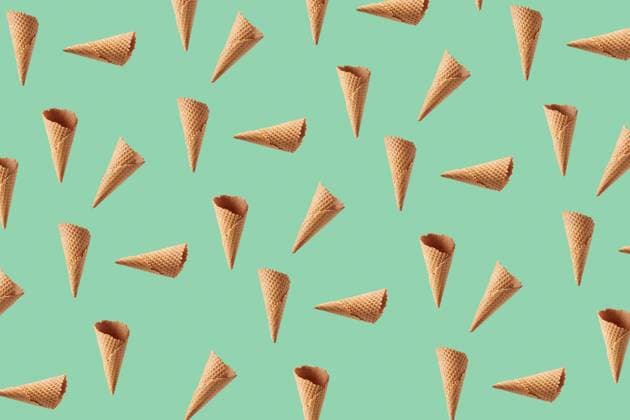 Flying pattern from crispy waffle cones for ice cream or gelato. Food pattern from chaotic floating crunchy waffle cones for making fresh sweet ice-cream or desserts against light green background. Copyright: xZoonar.com IaroslavxDanylchenkox 15427934