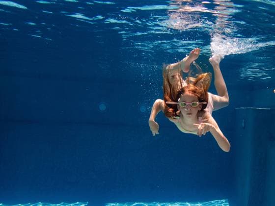 Girl child swims underwater in swimming pool in goggles in summer Gurnee, Illinois, United States CR_WVNP230125E-1091162-01 ,model released, Symbolfoto