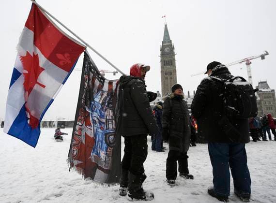 January 29, 2023, Ottawa, ON, CAN: A demonstrator holds flags as they mark the one year anniversary of the Freedom Convoy on Parliament Hill in Ottawa, on Sunday, Jan. 29, 2023. Ottawa CAN  - ZUMAc35_ 20230129_zaf_c35_007 Copyright: xJustinxTangx