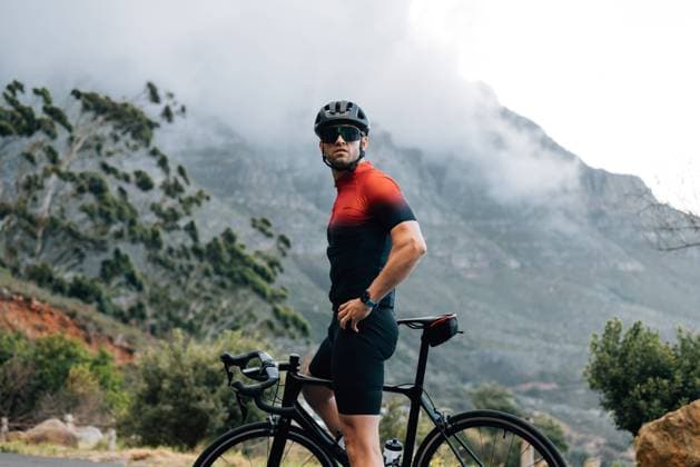 Creative Highlights Symbolbilder Male cyclist relaxing during his outdoor ride. Cyclist wearing helmet and glasses with bike against mountain looking away. Male cyclist relaxing during his outdoor ride. Cyclist wearing helmet and glasses with bike against mountain looking away. Copyright: xArtemxVarnitsinxArtemxVarnitsinx