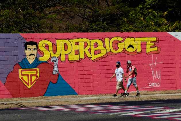 February 21, 2023: February 21,2023. A couple of men walk in front of a graffiti of super mustache, a personal campaign of Venezuelan President Nicolas Maduro, making himself look like a superhero fighting imperialism, in the city of Valencia, Venezuela. Photo: - ZUMAhe3_ 20230221_zbp_he3_002 Copyright: xJuanxCarlosxHernandezx