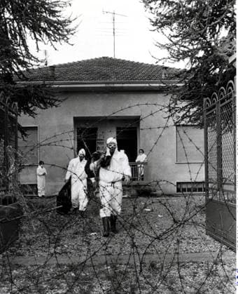 SCANPIX SWEDEN, 1976. Giftolycka i Seveso i Italien. Pa bilden: män i vita skyddskläder pa väg ut fran en byggnad. Sett genom hoprullad taggtrad. x20360x *** SCANPIX SWEDEN, 1976 Toxic accident in Seveso, Italy Pictured are men in white protective clothing exiting a building Seen through a rolled-up barbed wire x20360x  Copyright: xTTx 20360