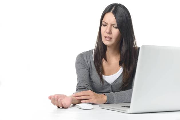 Junge Frau im Büro mit Schmerzen im Unterarm Young businesswoman rubbing and massaging her wrist to relieve cramps after using a computer mouse for too long at a stretch, on white Copyright: xZoonar.com LarsxZahnerx 6542933 ,model released, Symbolfoto ,property released