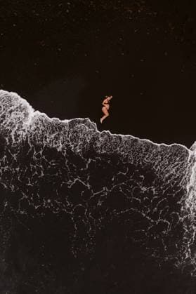 Creative Highlights Symbolbilder Aerial top view of anonymous pregnant female in bikini lying on dark sandy beach near waving sea with foam during summer vacation, Model released AlejandroDiaz_ID12906_392129_004 Copyright: xAlejandroxDiazx MR