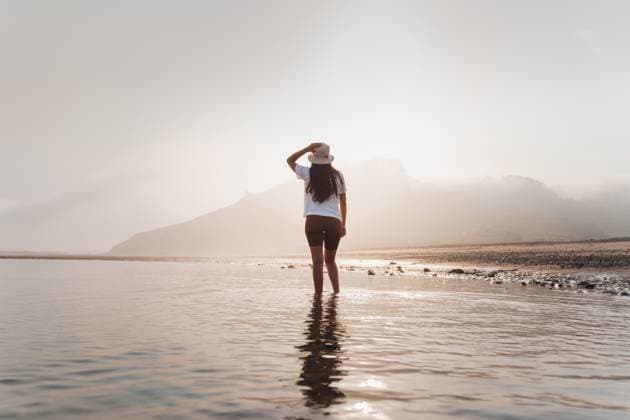 Creative Highlights Symbolbilder Back view of unrecognizable female in summer clothes and panama hat walking in sea water near shore against mountain on sunny day in Asturias, Model released PabloMenendez_ID12520_379881_017 Copyright: xPabloxMenendezx MR