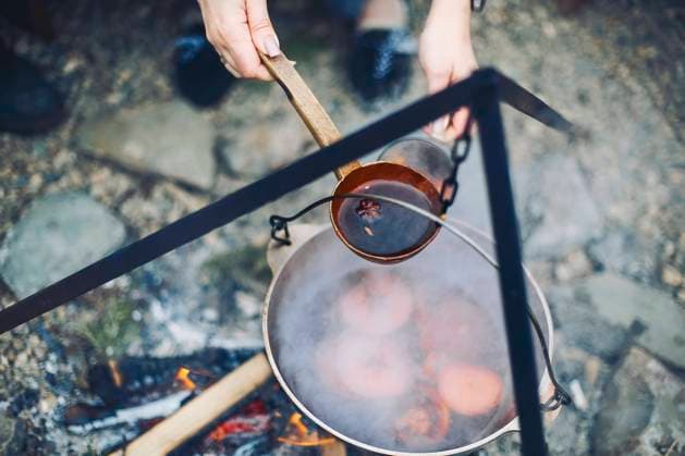 From above traditional mulled wine with slices of orange preparing in pot over burning logs From above traditional mulled wine with slices of orange preparing in pot over burning logs in winter in countryside Copyright: xZoonar.com DashaxPetrenkox 19250694