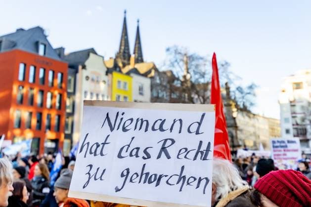 Schild: Niemand hat das Rech zu gehorchen - Aktionswochenende öStoppt das Töten für Waffenstillstand und Verhandlungen!˜ von Deutsche Friedensgesellschaft Vereinigte KriegsdienstgegnerInnen auf dem Alter Markt in Köln 25.02.2023 Köln Altstadt NRW Deutschland *** Sign Nobody has the right to obey Action Weekend öStop the Killing for Ceasefire and Negotiations ˜ by Deutsche Friedensgesellschaft Vereinigte KriegsdienstgegnerInnen at the Alter Markt in Cologne 25 02 2023 Cologne Altstadt NRW Germany