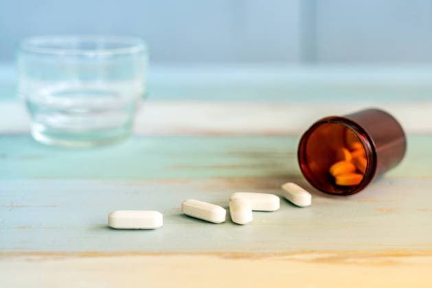 medicine spilling out Pills medicine spilling out of pill bottle on vintage wooden background Copyright: xZoonar.com VichayaxKiatying-Angsuleex 14458464