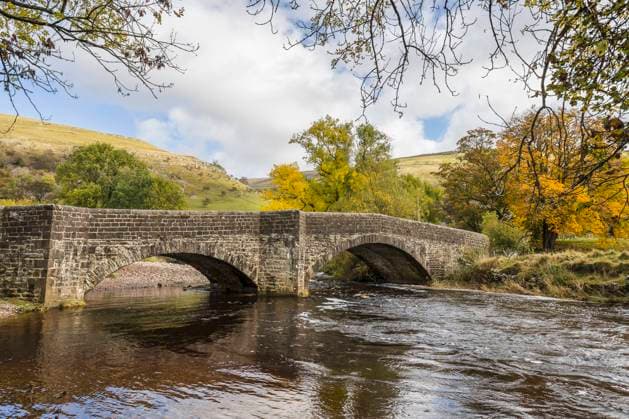 Colourful trees surround and frame the beautiful bridge which spans the River Wharfe in Bucken in the Yorkshire Dales. Copyright: xLoopxImages JasonxWellsx JWS00623WT261