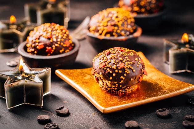 Small chocolate pastry cakes for Christmas with candles and ornaments Small chocolate pastry cakes for Christmas with candles and ornaments Copyright: xZoonar.com IngridxBalabanovax 19464431
