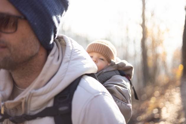 Sporty father carrying his infant son wearing winter jumpsuit and cap in backpack carrier hiking in autumn forest. Sporty father carrying his infant son wearing winter jumpsuit and cap in backpack carrier hiking in autumn forest Copyright: xZoonar.com MatejxKastelicx 19508725