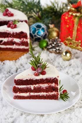 Piece of Red Velvet Cake Red Velvet Cake is a traditional red chocolate cake topped with white buttercream and decorated with a Christmas wreath of candied cranberries and rosemary. Copyright: xZoonar.com MarynaxVoronovax 19518660