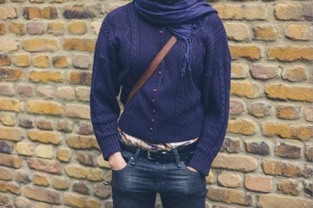 RECORD DATE NOT STATED A young woman wearing a blue cardigan and a scarf is standing by a brick wall; einer Jung Frau wearing einer Blau Wolljacke und einer Tuch ist stehend indem einer Backstein Mauer ING_37571_04740