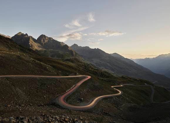 Austria, Vehicle light trails stretching along winding mountain pass in Alps, CVF02290