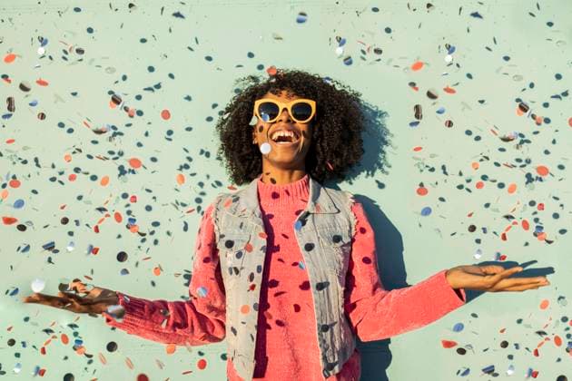 Cheerful woman with confetti enjoying in front of green wall model released, Symbolfoto, JCCMF09145