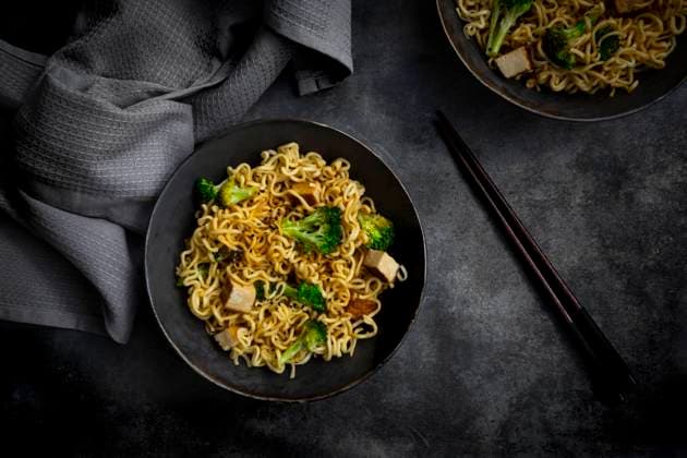 Studio shot of plate of ready-to-eat vegan noodles with broccoli, tofu and soy sauce, LVF09280