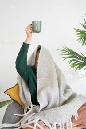 Woman holding coffee cup sitting under blanket at home model released, Symbolfoto property released, SVKF01277