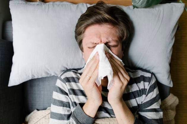 Man blowing nose in napkin lying on bed model released, Symbolfoto property released, TYF00696