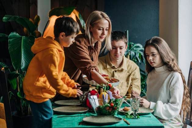 Woman serving food to family having Easter dinner at home model released, Symbolfoto property released, VSNF00463