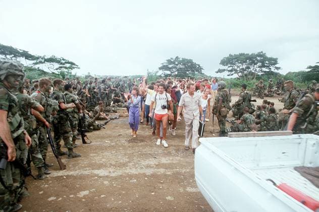 RECORD DATE NOT STATED American students wave to U.S. military personnel as they walk toward the airport during Operation Fury. Subject Operation Series: URGENT FURY Country: Grenada (GRD) Copyright: xpiemagsx nararecdefpie08012022-38879 !ACHTUNG AUFNAHMEDATUM GESCHÄTZT!
