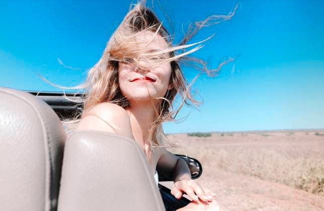 Happy woman sitting on passenger seat in car Joyful young female in summer clothes sitting on passenger seat of cabriolet and looking at camera over shoulder during road trip Copyright: xZoonar.com DashaxPetrenkox 16727850 ,model released, Symbolfoto ,property released