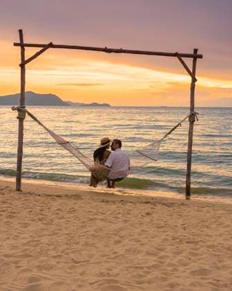 Men and women watching sunset from a hammock on the beach in Pattaya Thailand Ban Amphur beach Men and women are watching the sunset from a hammock on the beach in Pattaya Thailand Ban Amphur beach. couple walking on a tropical beach with palm trees and hammock during sunset Copyright: xZoonar.com FokkexBaarssenx 19607085 ,model released, Symbolfoto ,property released