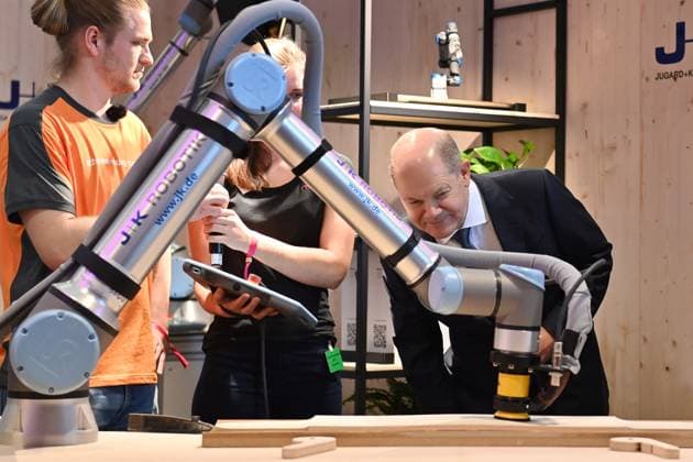 News Themen der Woche KW10 News Bilder des Tages Bundeskanzler Olaf SCHOLZ, beim Messerundgang,laesst sich von zwei Lehrlingen des Schreinerhandwerks einen Schleifroboter demonstrieren. Muenchener Spitzengespraech der Deutschen Wirtschaft,Zentralverband des deutschen Handwerks,ZDH,anlaesslich der Internationalen Handwerksmesse IHM 2023 in Muenchen,10.03.2023 *** Federal Chancellor Olaf SCHOLZ, at the fair tour, lets two apprentices of the carpenters craft demonstrate a grinding robot Munich top discussion of the German economy, central association of the German handicraft, ZDH, on the occasion of the international handicraft fair IHM 2023 in Munich,10 03 2023