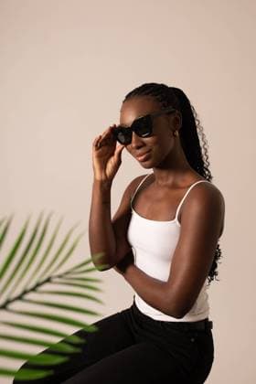 Female black model with sunglasses and a palm leaf at the studio Barcelona, Catalonia, Spain R_IFWQ230308-1148724-01 ,model released, Symbolfoto