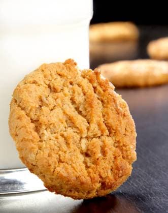 A fresh organic oatmeal cookie leaning against a glass of milk. Copyright: xCedricxCarterx xDesignxPicsx , 30303240 Copyright: CedricxCarterx xDesignxPics 30303240