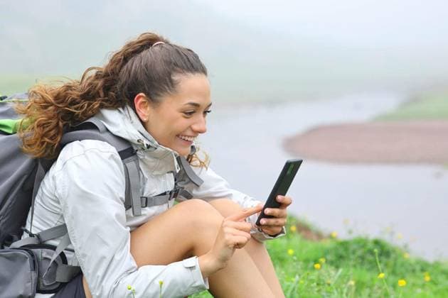  Happy hiker using smart phone sitting in nature, Happy hiker using smart phone sitting in nature in a riverside, Happy hiker using smart phone sitting in nature in a riverside model released, Symbolfoto , 27.02.2023, Copyright: xPheelingsMediax Panthermedia33703973.jpg