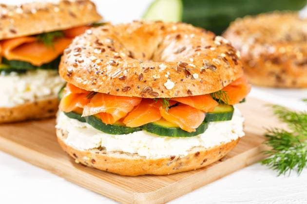 Bagel Brötchen Sandwich zum Frühstück belegt mit Lachs Fisch auf einem Brett in Stuttgart, Deutschland Stuttgart, Deutschland - 15. März 2023: Bagel Brötchen Sandwich zum Frühstück belegt mit Lachs Fisch auf einem Brett in Stuttgart, Deutschland. *** Bagel roll sandwich for breakfast topped with salmon fish on a board in Stuttgart, Germany Stuttgart, Germany 15 March 2023 Bagel roll sandwich for breakfast topped with salmon fish on a board in Stuttgart, Germany