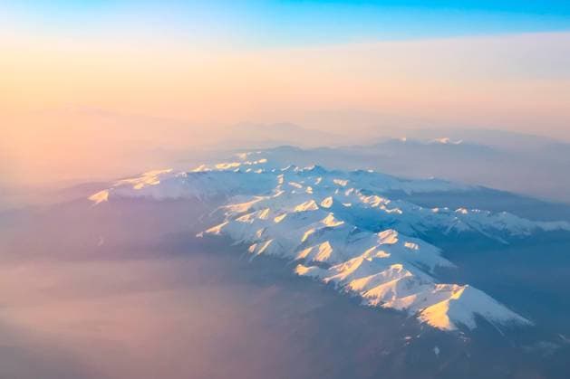 Aerial sunset, sunrise over mountains silhouettes Aerial view of colorful sunrise over mountains snow peaks and silhouettes, shot from airplane Copyright: xZoonar.com NataliyaxNazarovax 15833864