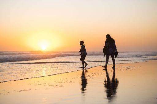RECORD DATE NOT STATED A silhouette of a person walking down a sandy beach, illuminated by the soft light of a sunset over the ocean *** einer Schattenriss des einer person Spazierengehen nieder einer sandiger beach, beleuchtet indem der weich Licht des einer Sonnenuntergang trueber der Ozean 15030708 ,model released, Symbolfoto