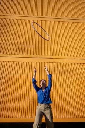 Playful woman tossing hula hoop standing in front of cargo container model released, Symbolfoto, AXHF00321