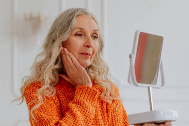 Creative Highlights Symbolbilder Senior woman with gray hair looking in mirror at home model released, Symbolfoto property released, MDOF00842