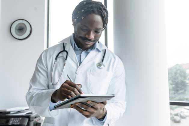 IMAGO Creative, Diversity, Pflege im Krankenhaus Young doctor using tablet PC at clinic model released, Symbolfoto property released, OSF01397