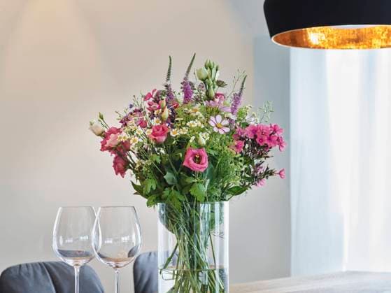 Fresh flower vase by wineglasses in apartment property released, RORF03405