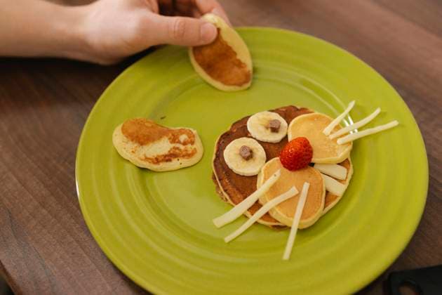 Man decorating pancakes in shape of bunny at home model released, Symbolfoto property released, VIVF00418