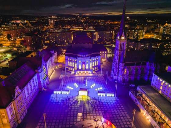 Illuminarium Chemnitz Vier Tage lang - vom 23. bis 26. März 2023 verwandelt das Illuminarium - das Klang-Lichtfestival der Filmnächte Chemnitz den Chemnitzer Theaterplatz in das mit etwa 45 Metern Durchmesser wohl größte Ziffernblatt der Welt . Die Woche von Frühlingsanfang und Zeitumstellung nehmen die Filmnächte Chemnitz und ihre Veranstalterin, die Meisterwerke Neo GmbH, zum Anlass, den Umgang der Menschen mit dem Thema Zeit künstlerisch zu beleuchten - und das im Wortsinn: Jeweils in den Abendstunden locken Video- und Lichtkunst sowie weitere Angebote die Chemnitzerinnen und Chemnitzer und die Gäste der künftigen Kulturhauptstadt Europas auf den schönsten Platz der Stadt , der so in ein neues Licht getaucht wird. Chemni