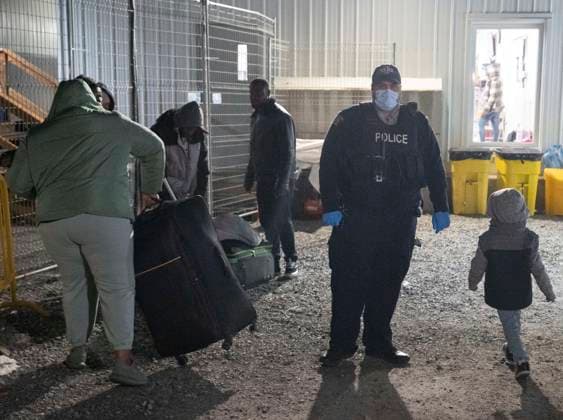 March 25, 2023, Champlain, New York, United States: An RCMP officer pulls a family of asylum seekers aside after they crossed the border just after the midnight deadline at Roxham Road from New York into Canada Saturday March 25, 2023 in Champlain, NY.. The irregular border crossing is now permanently closed. Champlain United States  - ZUMAc35_ 20230325_zaf_c35_005 Copyright: xRyanxRemiorzx