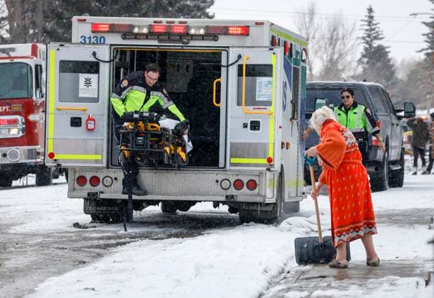 March 27, 2023, Calgary, AB, CANADA: A woman clears snow from her sidewalk as first responders attend the scene of a house explosion that injured several people, destroyed one home and damaged others in Calgary, Alta., Monday, March 27, 2023. Calgary CANADA  - ZUMAc35_ 20230327_zaf_c35_090 Copyright: xJeffxMcintoshx