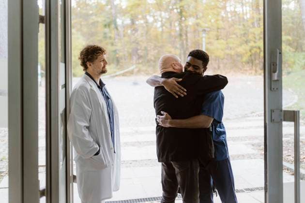 Senior male patient embracing nurse while standing by doctor at hospital doorway Germany, Berlin, model released, property released Copyright: xMaskotx , MA100136 MA100136