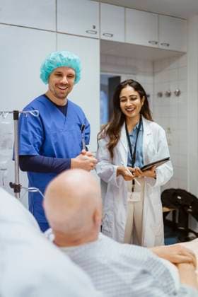 Happy healthcare workers talking to senior male patient in hospital Germany, Berlin, model released, property released Copyright: xMaskotx , MA100150 MA100150