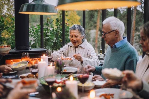 Senior woman serving food to male friend at dinner party Sweden, Stockholm, model released, property released Copyright: xMaskotx , MA100220 MA100220