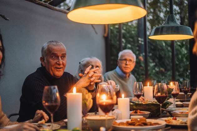 Mature man with hands clasped sitting by male and female friends at dinner party Sweden, Stockholm, model released, property released Copyright: xMaskotx , MA100247 MA100247
