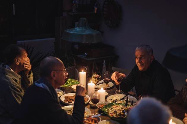Male friends talking to each other during dinner party at night Sweden, Stockholm, model released, property released Copyright: xMaskotx , MA100258 MA100258