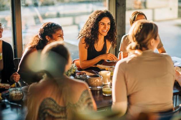 Young woman laughing with female friends during breakfast at retreat center Sweden, Stockholm, model released, property released Copyright: xMaskotx , MA100345 MA100345